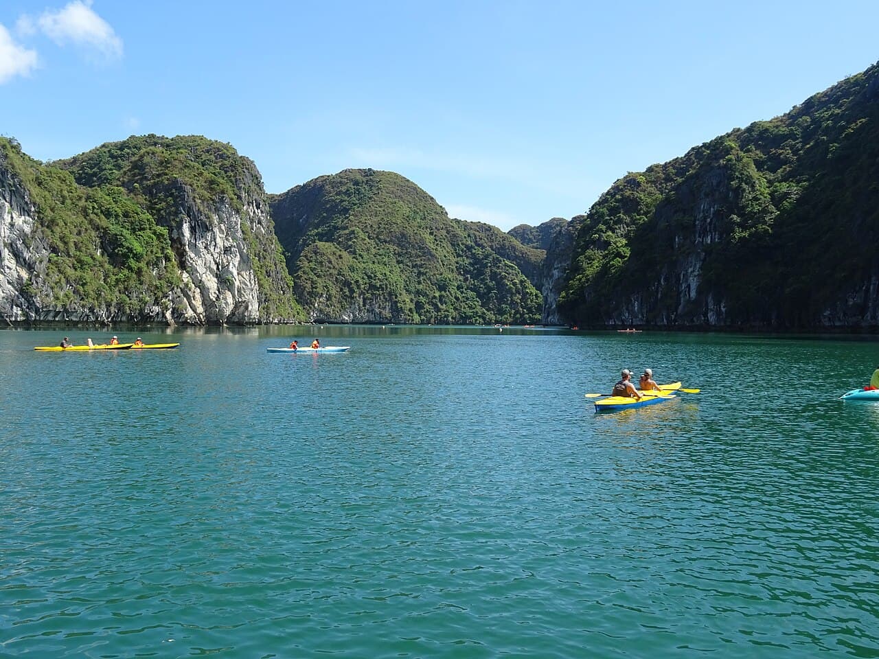 Kayakers paddling between karsts in Lan Ha Bay